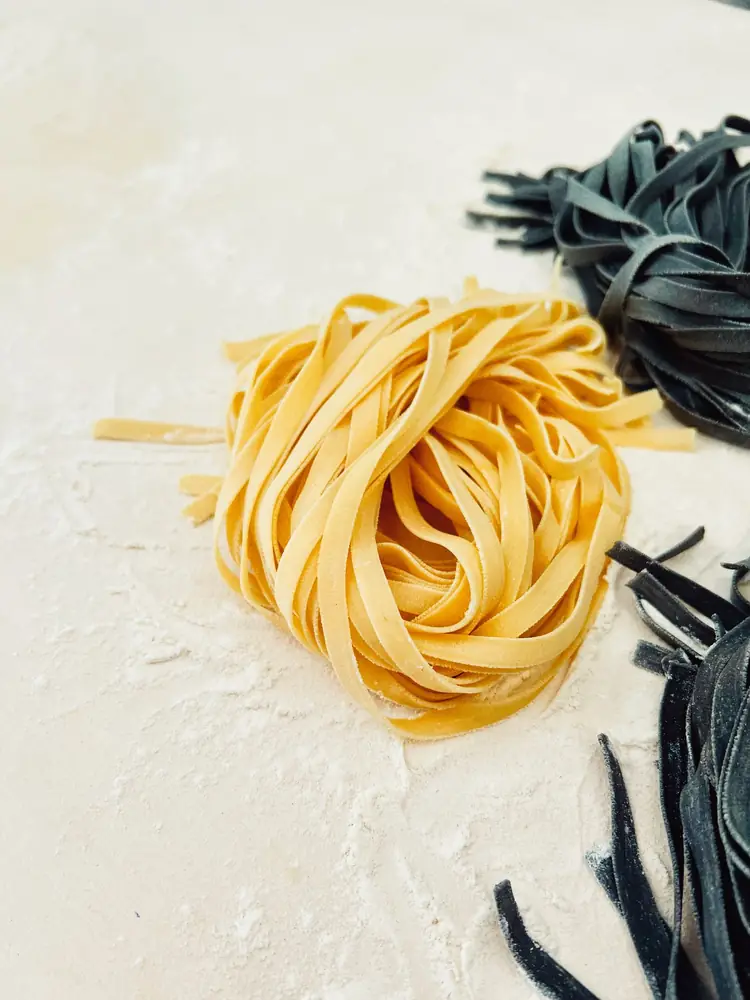Cuib de tagliatelle lângă paste cu cerneală de sepie